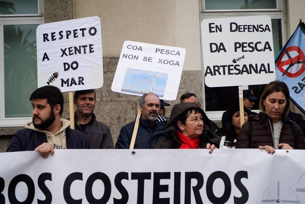 Cientos de personas protestan con carteles durante una concentración contra el plan de parques eólicos marinos frente a la Delegación del Gobierno en A Coruña, a 11 de marzo de 2023 Cientos