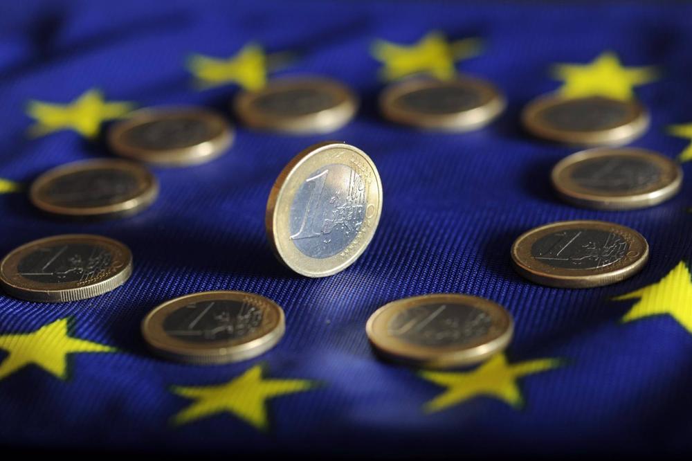 Archivo - Moneda de euro sobre una bandera europea. Archivo