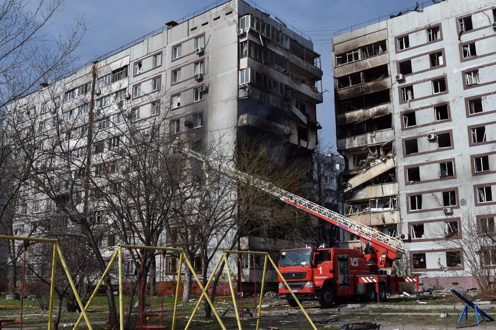 Firefighters attempt to extinguish a fire in an attacked building in Zaporiyia, Ukraine. Firefighters