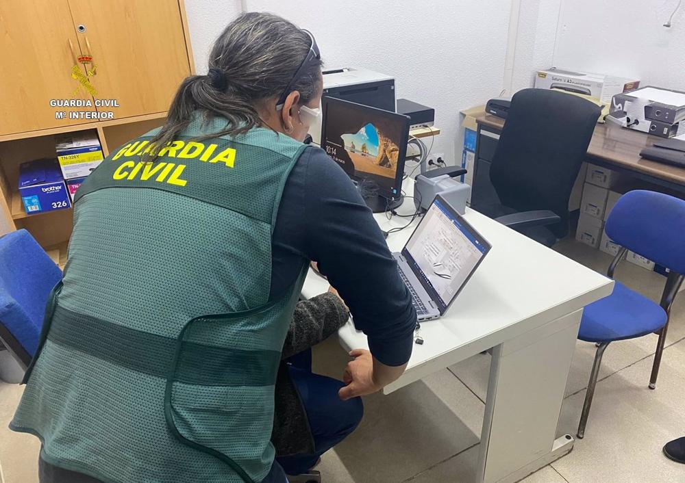 Una agente de la Guardia Civil revisa material informático Una