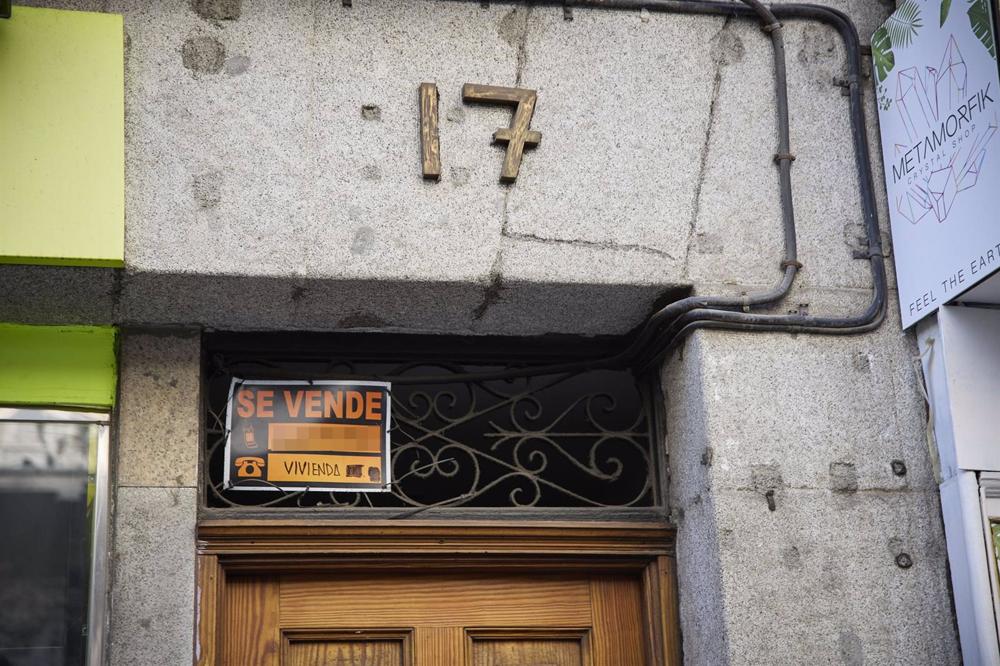 Cartel de una vivienda en venta en el escaparate en el barrio de Almagro Cartel