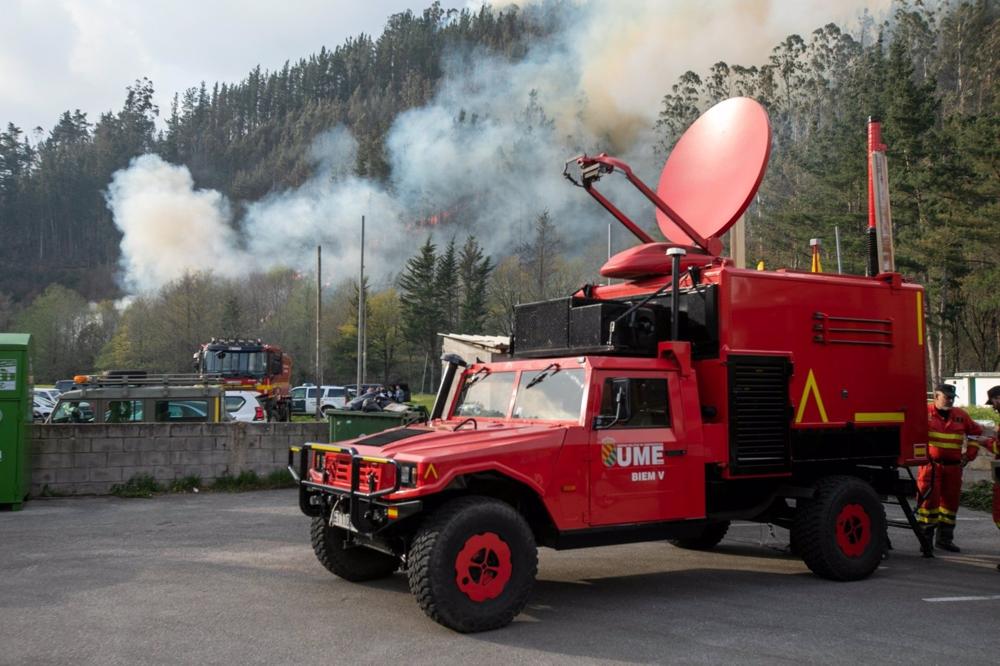 Un vehículo de la UME trabajando en la extinción del incendio forestal de Navelgas, en Tineo. Un