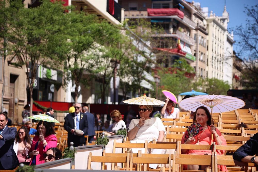 Las personas se protegen del intenso Sol en las sillas de la Campana, esperando la llegada de las cofradías, a 02 de abril del 2023, en Sevilla, (Andalucía, España). Las