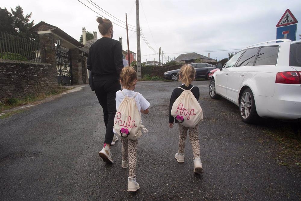 Archivo - Una madre acompaña a sus dos hijas Archivo