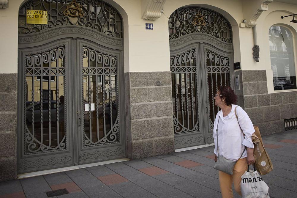 Archivo - Una observa el anuncio de una vivienda de lujo en venta en el barrio de Almagro Archivo