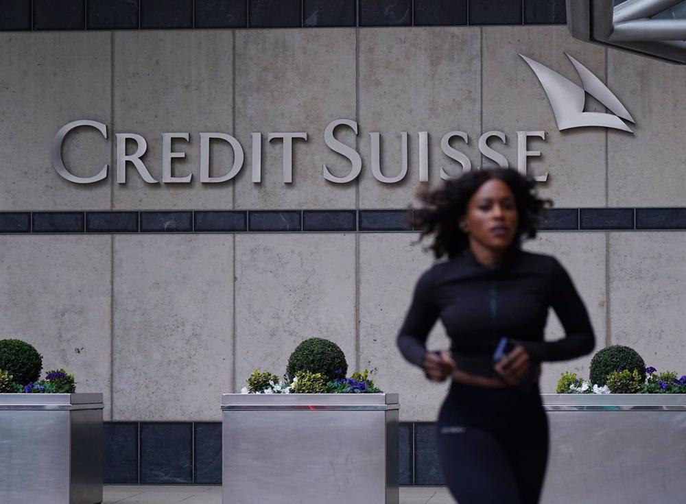 Archivo - 19 March 2023, United Kingdom, London: A woman runs in front of the Credit Suisse UK offices in Canary Wharf. Swiss banking giant UBS is acquiring its ailing smaller rival Credit Suisse in an emergency rescue deal, with the historic mega-merger Archivo