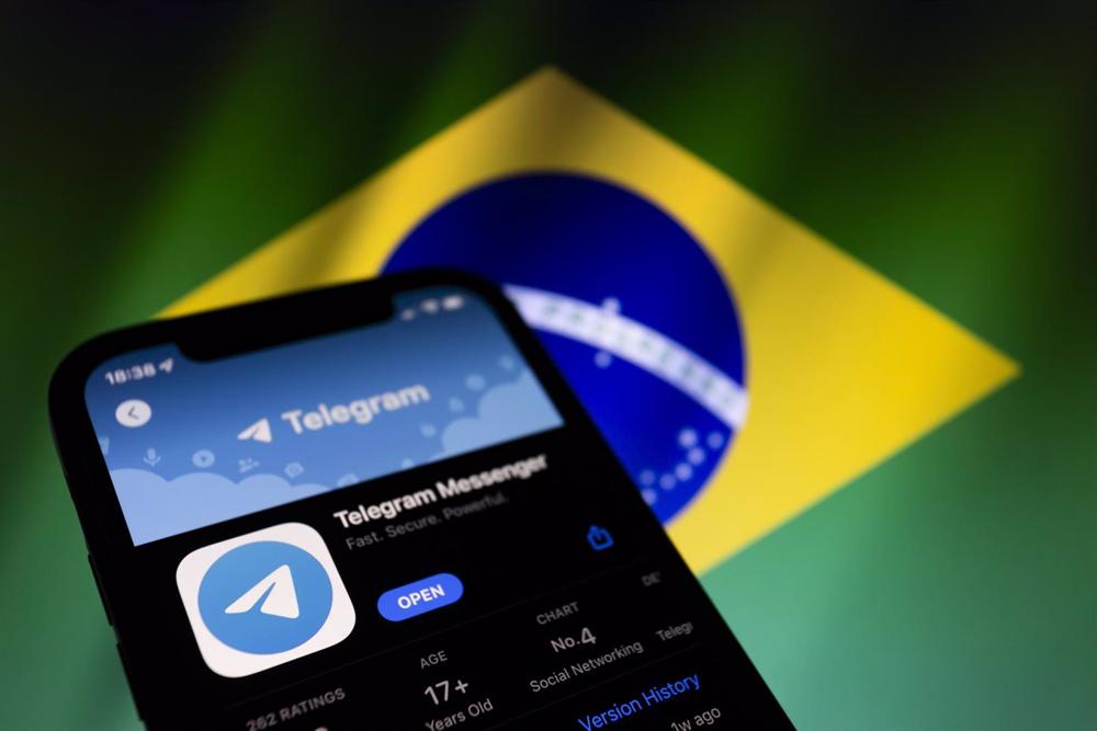 Archivo - Aplicación de Telegram junto a la bandera de Brasil Archivo