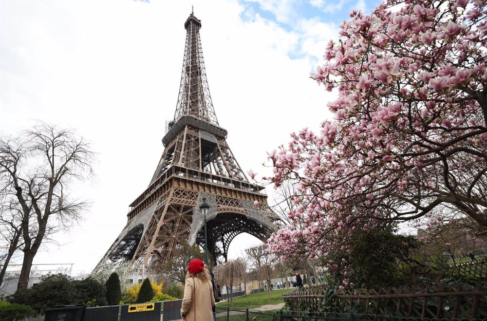 Archivo - PARIS, March 20, 2023 -- A woman passes by magnolia blossoms at the Champ de Mars near the Eiffel Tower in Paris, France, March 19, 2023.,Image: 763930024, License: Rights-managed, Restrictions: , Model Release: no, Credit line: Gao Jing / Xinh Archivo
