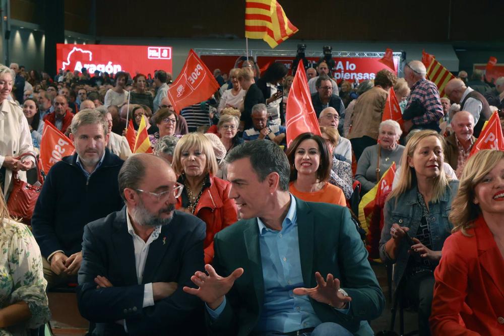 El presidente del Gobierno y secretario general del PSOE, Pedro Sánchez (d) y el secretario general del PSOE de Aragón y candidato a la Presidencia del Gobierno autonómico, Javier Lambán (i), participan en un acto de campaña, en la Sala Multiusos del Audi El