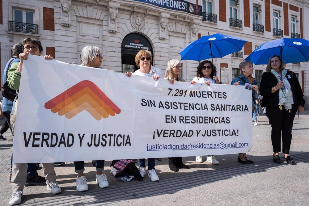 Varias personas sostienen una pancarta durante una rueda de prensa de Verdad y Justicia en las Residencias de Madrid Varias