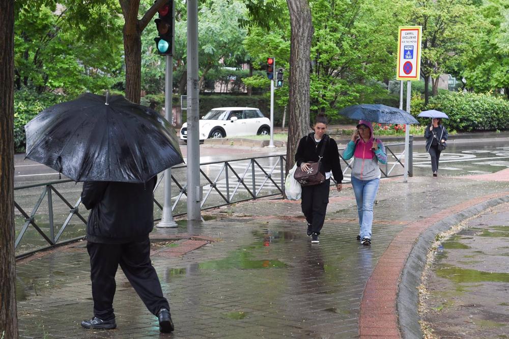 Varias personas pasean bajo la lluvia, a 23 de mayo de 2023, en Madrid (España). La Agencia Estatal de Meteorología (Aemet) prevé lluvias en la región madrileña todo lo que queda de semana ocasionadas por una DANA (Depresión Aislada en Niveles Altos) que Varias