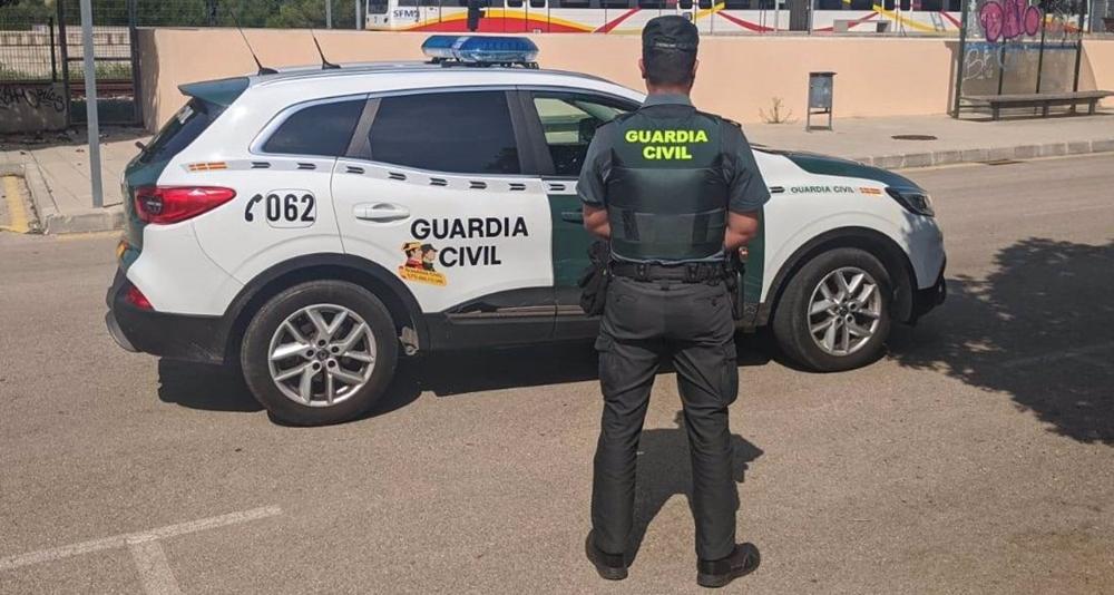 Un agente de la Guardia Civil, de espaldas, junto a un vehículo. Un