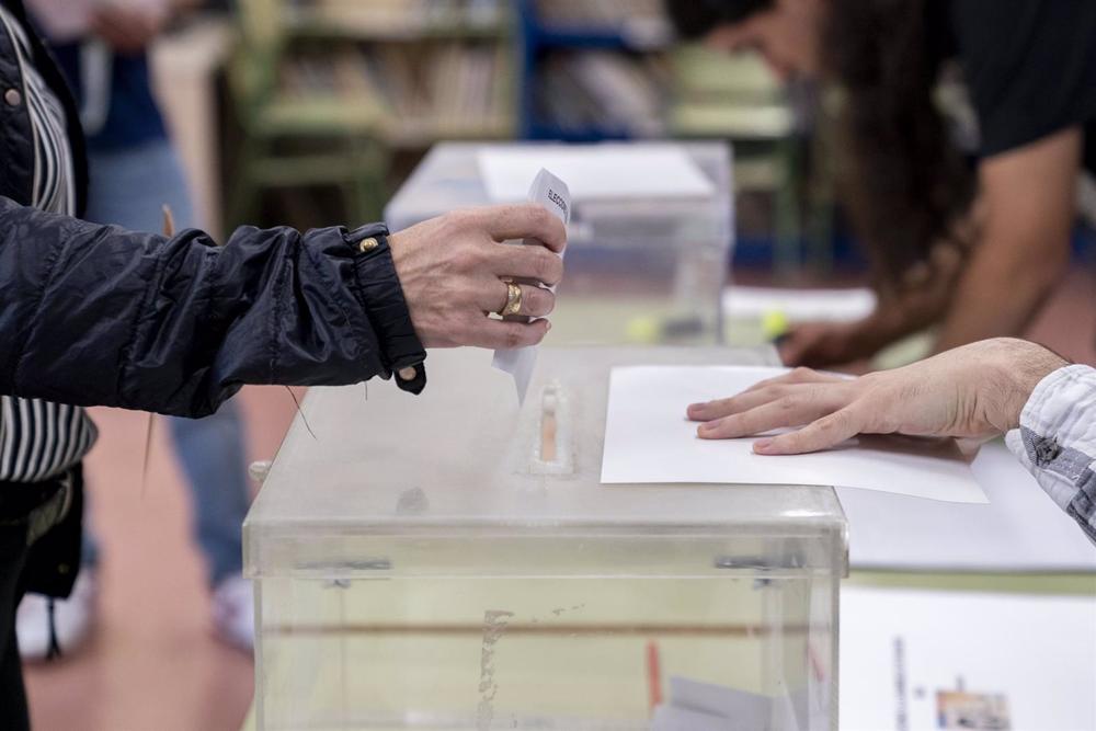 Una persona mete su voto en la urna en un colegio electoral, a 28 de mayo de 2023, en Madrid (España). Hoy, 28M, se celebran en España elecciones municipales en un total de 8.131 ayuntamientos, elecciones autonómicas en 12 comunidades autónomas y en las Una