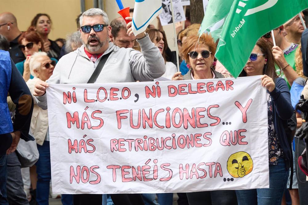 Funcionarios de Justicia sujetan una pancarta durante una concentración frente a la sede nacional del PSOE. Funcionarios