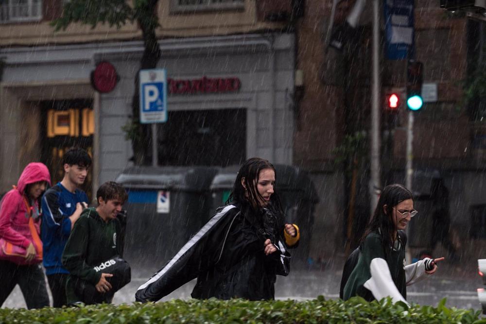 Varias personas caminan bajo la lluvia, a 29 de mayo de 2023, en Madrid (España). Varias